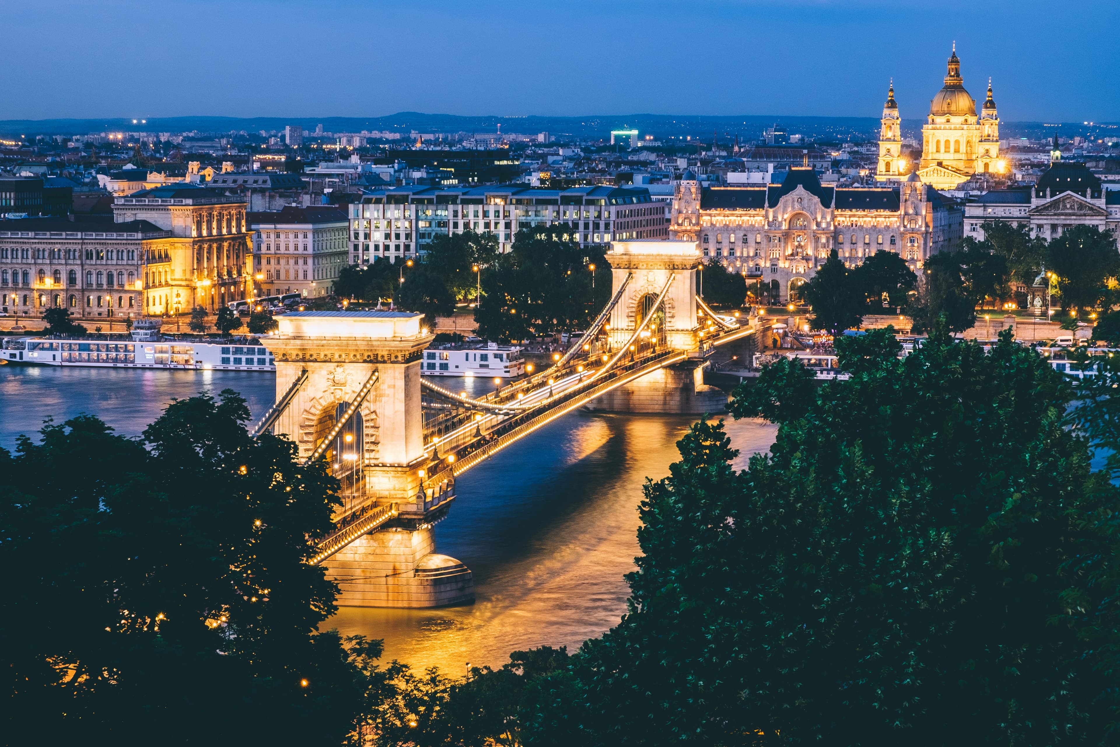 Die Széchenyi-Kettenbrücke in Budapest bei Sonnenaufgang, mit ihren steinernen Löwen und den geschwungenen Stahlketten über der Donau