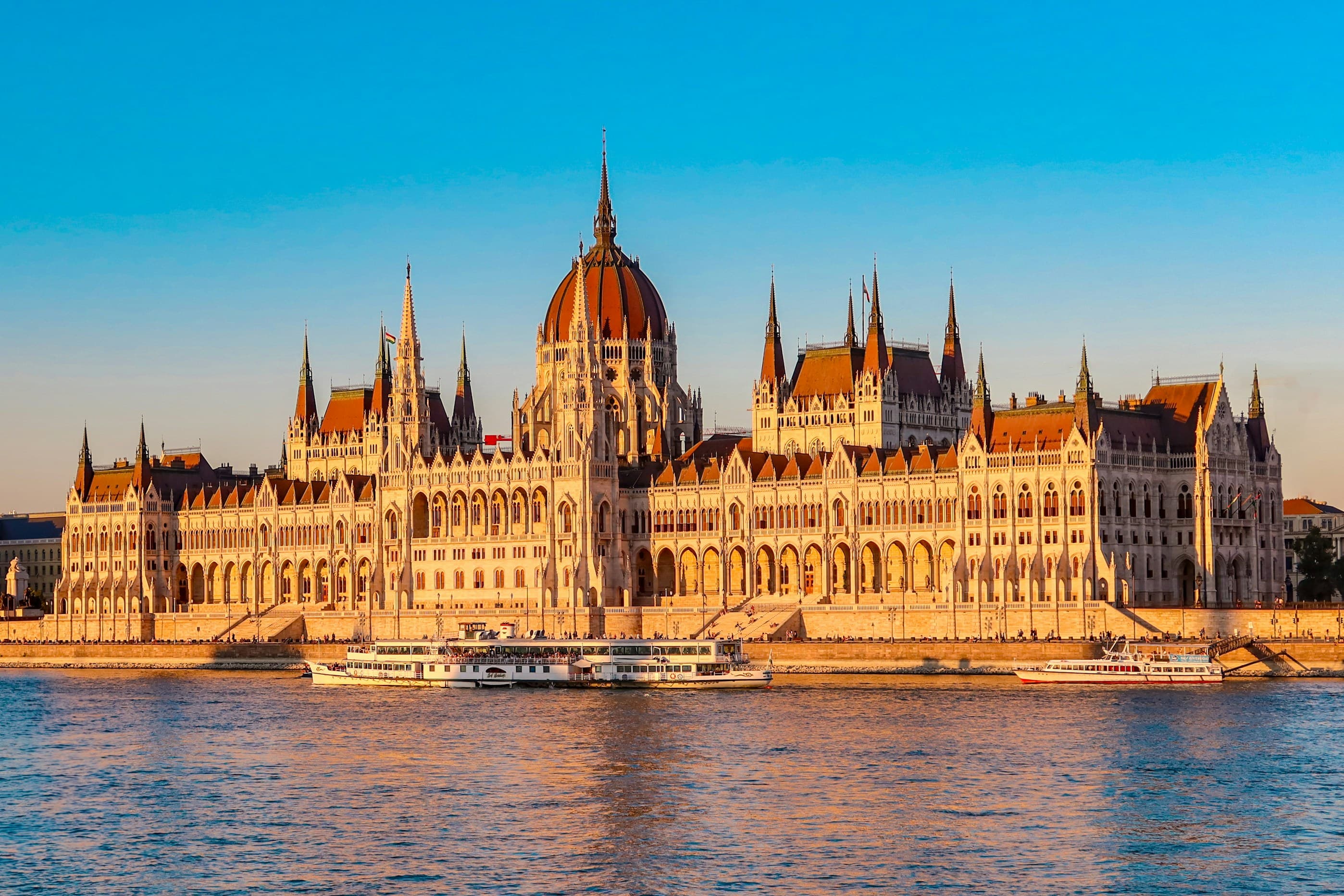 Flusskreuzfahrtschiff auf der Donau mit Blick auf das Parlament in Budapest