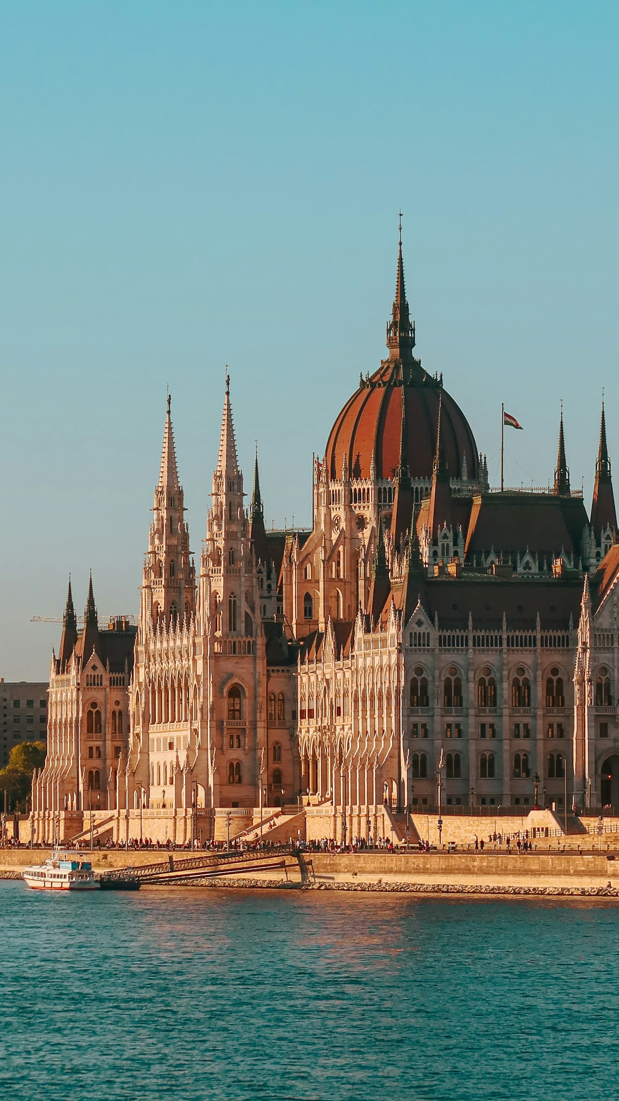 Das ungarische Parlamentsgebäude in Budapest bei Tag, von der Donau aus gesehen, mit seiner neogotischen Fassade und der zentralen Kuppel